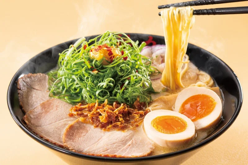 濃厚鶏白湯らぁめん。九条ねぎやチャーシュー、半熟味玉をのせ麺を持ち上げた一杯