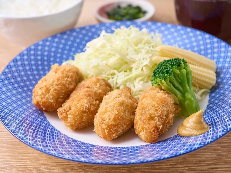 サクぷり牡蠣フライ定食。青い皿に牡蠣フライ4個、千切りキャベツ、ブロッコリー