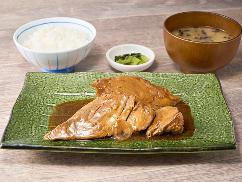 まぐろの煮付け定食。緑の皿の煮付けにご飯、漬物、味噌汁が付く