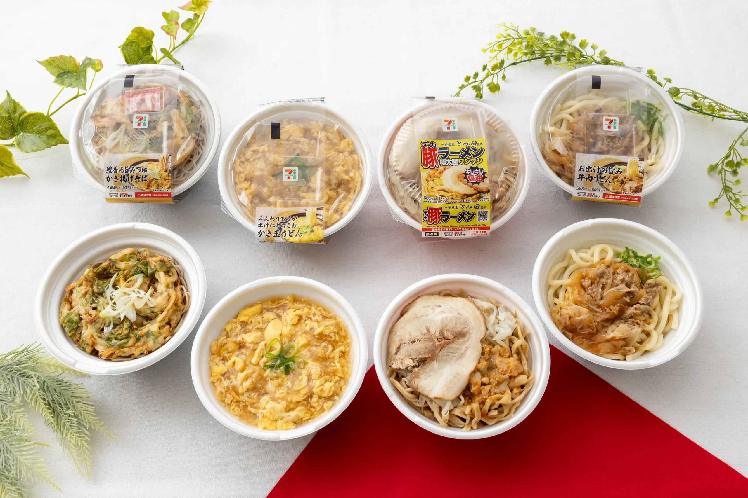 セブン‐イレブンの温かい麺類のパック4個と器に盛った4品が並ぶ