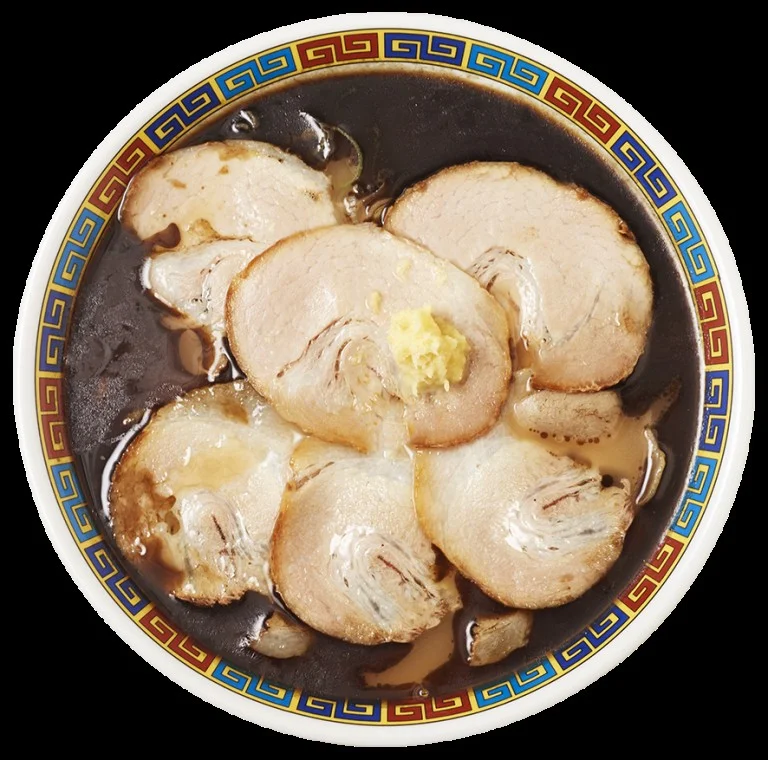 旭川ラーメン 蜂屋 肉増し。チャーシューが複数枚のった黒いスープの丼