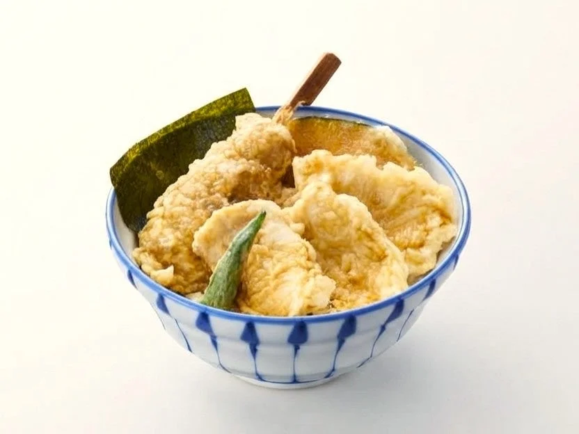 鶏天丼。青い縞模様の丼に天ぷらと海苔、ししとうが盛られている