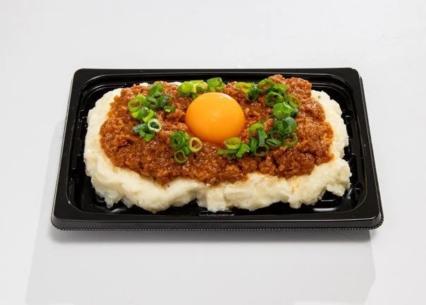 愛知を旅する 台湾ミンチ風ポテサラ。黒い容器に肉味噌、卵黄、ねぎ