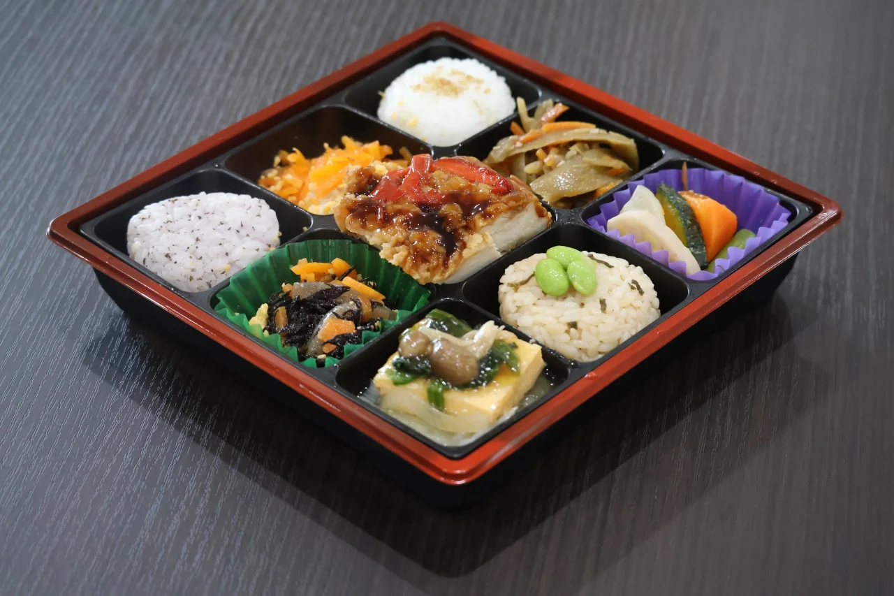 3色ご飯と味わい和風弁当の仕切り容器に9品が入った様子