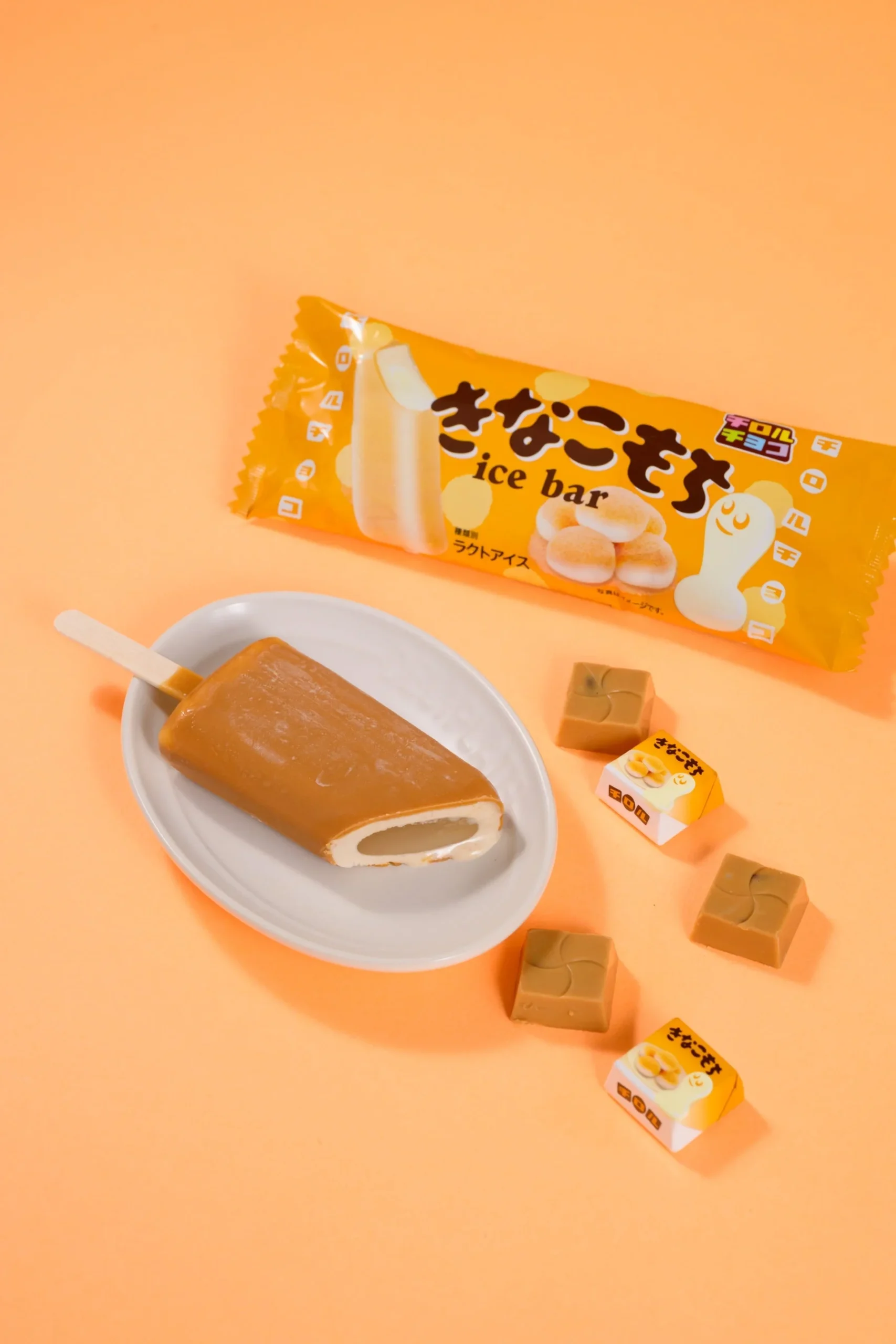チロルチョコきなこもちアイスバーのパッケージと皿に載せたバー、チョコ