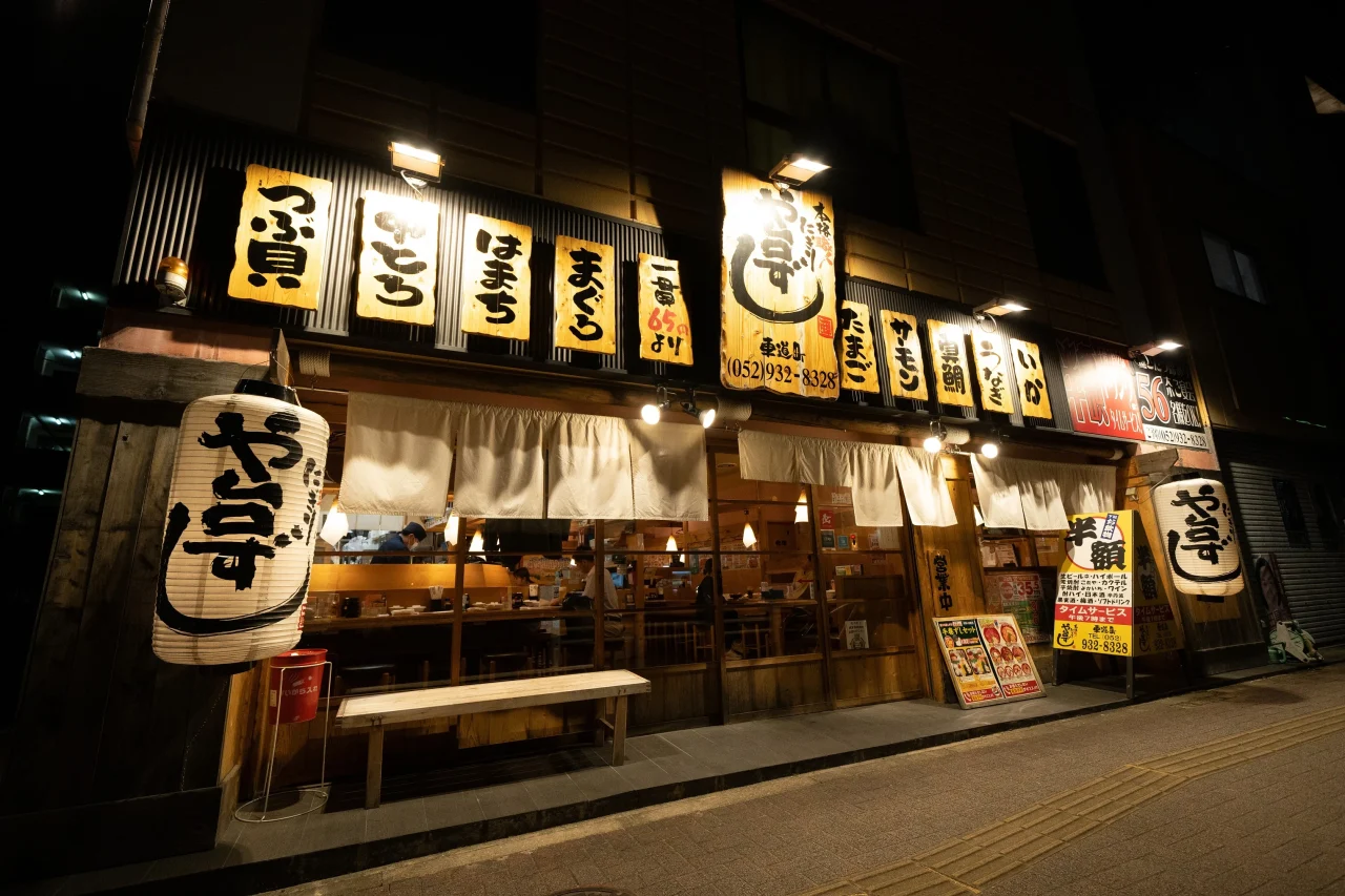 や台ずし外観。夜の店頭に提灯と木札の看板が並ぶ