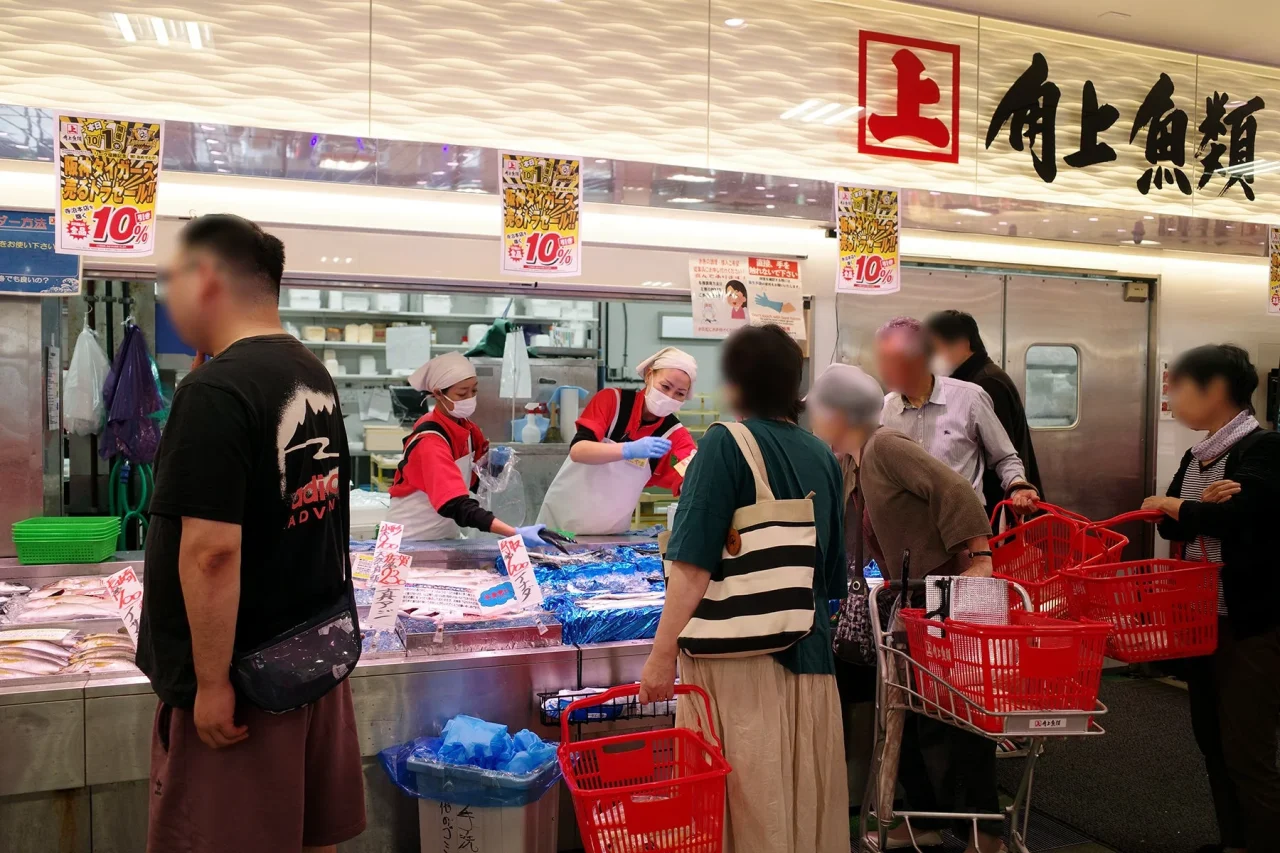 2025年開催の様子、角上魚類の売場で買い物客と従業員が並ぶ