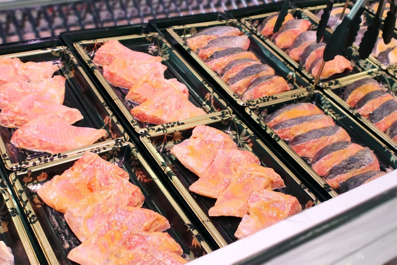 角上魚類 自社製西京漬け各種が黒いトレーに並ぶ売場