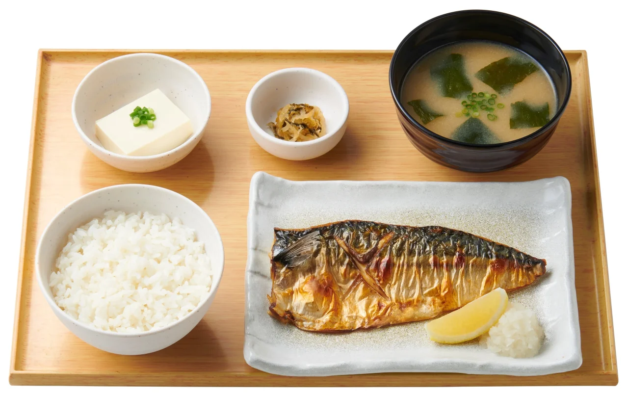 サバの塩焼定食。焼き鯖、ご飯、味噌汁、豆腐小鉢、小鉢をお盆に並べた定食