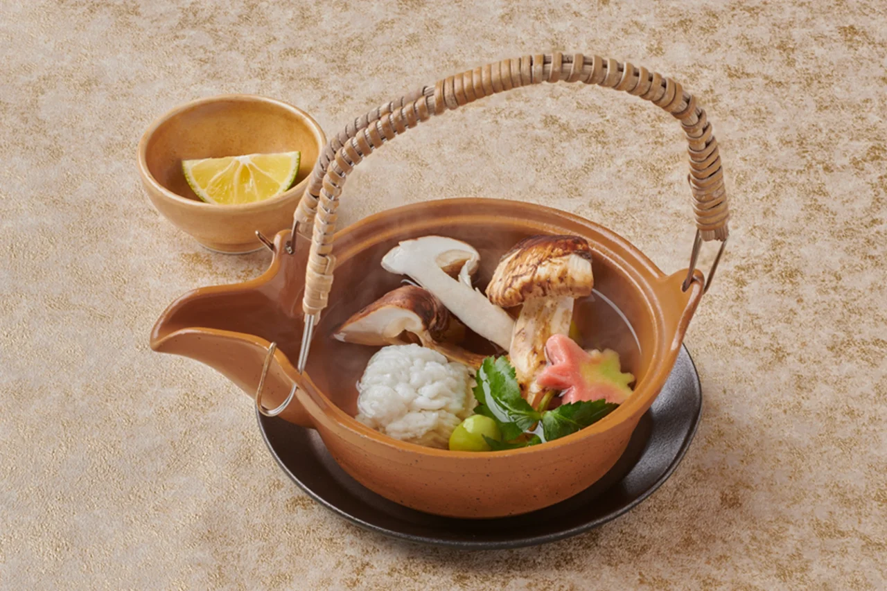 松茸の土瓶蒸し。松茸などの具が入った土瓶とすだちを添えた様子