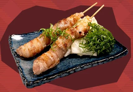 青い角皿に盛られた肉巻きエビ串2本と大葉の薬味