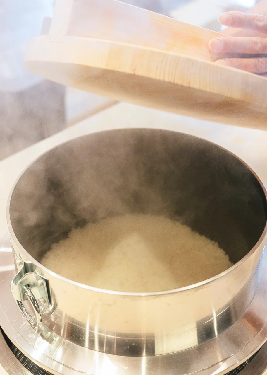 大かまどごはん 木蓋を開けた釜から湯気が立つ炊きたてのごはん
