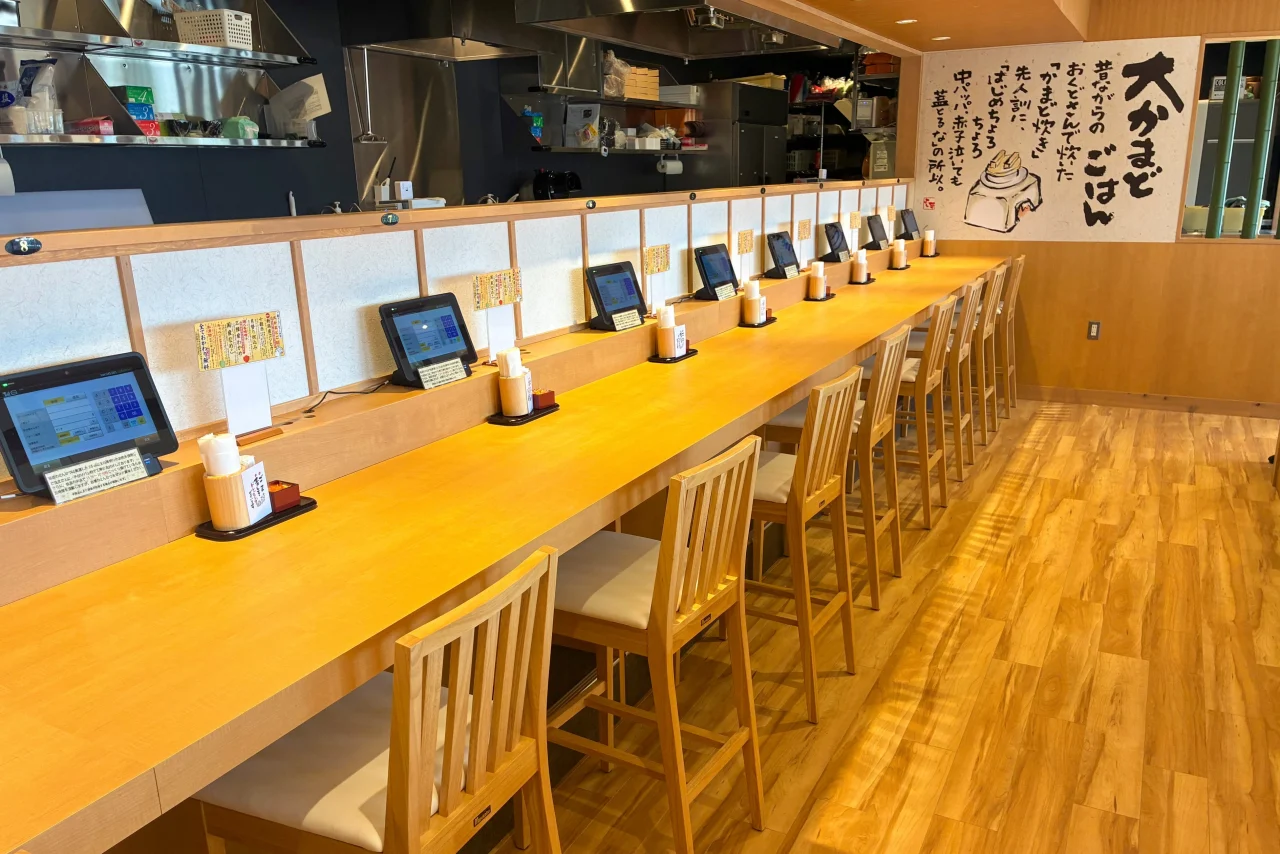 木目調のカウンター席。タブレット端末が並ぶ店内