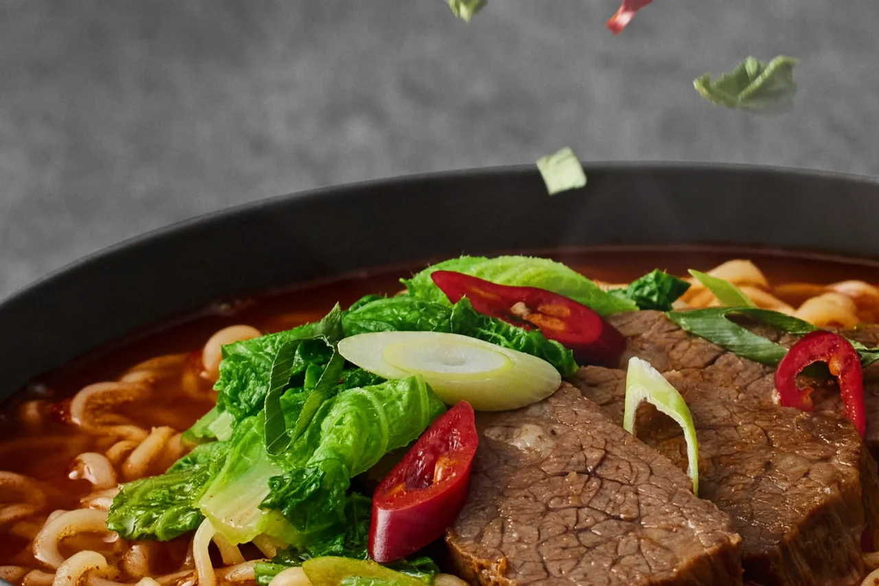 満足感のかやく。白菜・ねぎ・唐辛子と肉をのせた赤いスープの麺