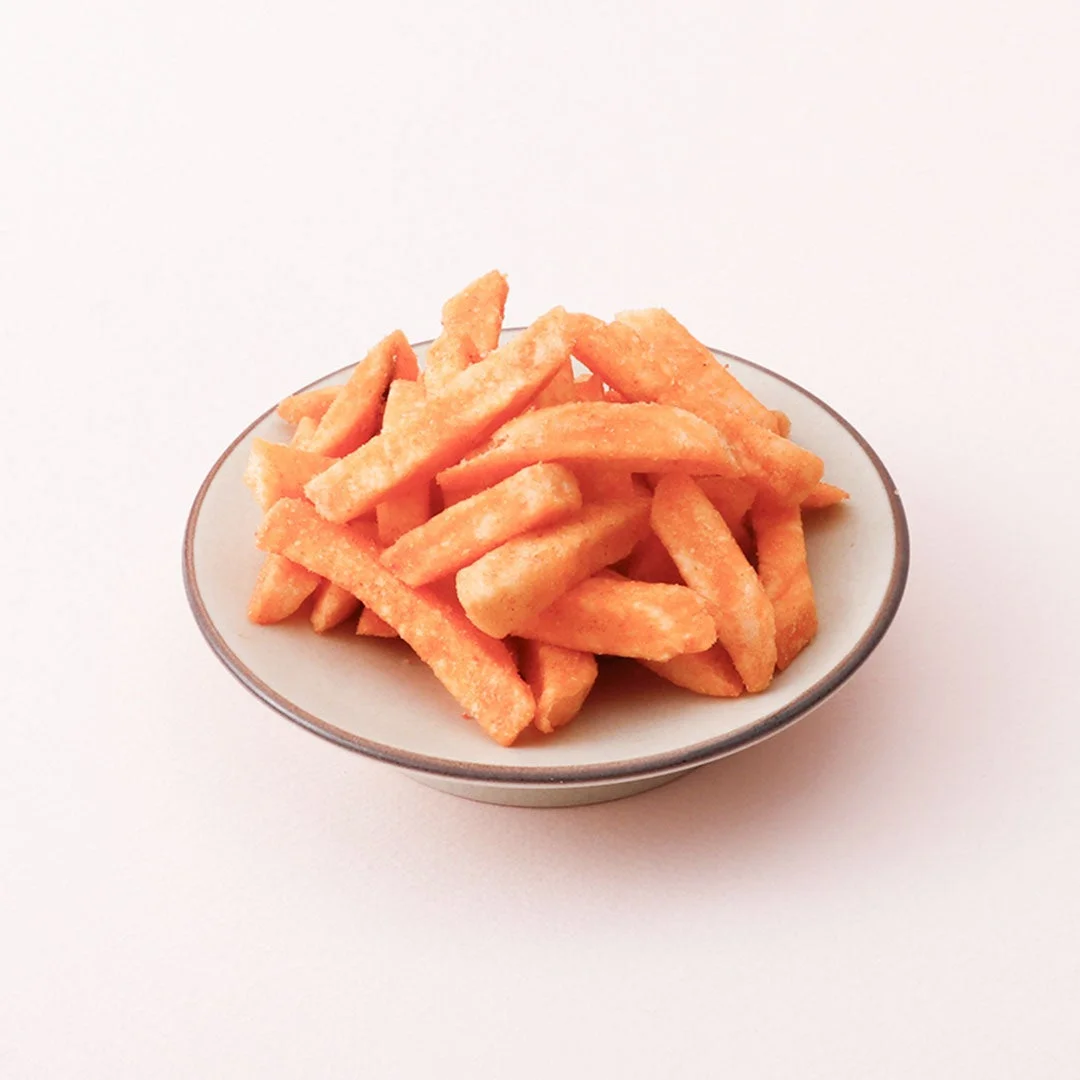 明太ポテトスティックが器に盛られたオレンジ色のスティック状スナック