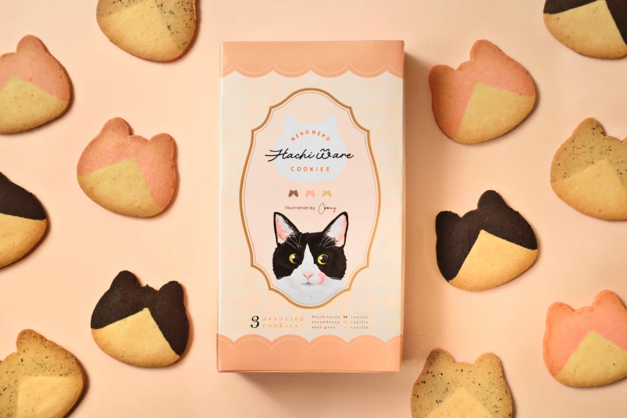 ねこねこはちわれクッキーのパッケージと周囲に並ぶねこ型クッキー
