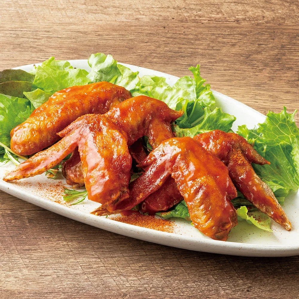 レタスを敷いた白い皿に盛られた、赤茶色のソースをまとった手羽先