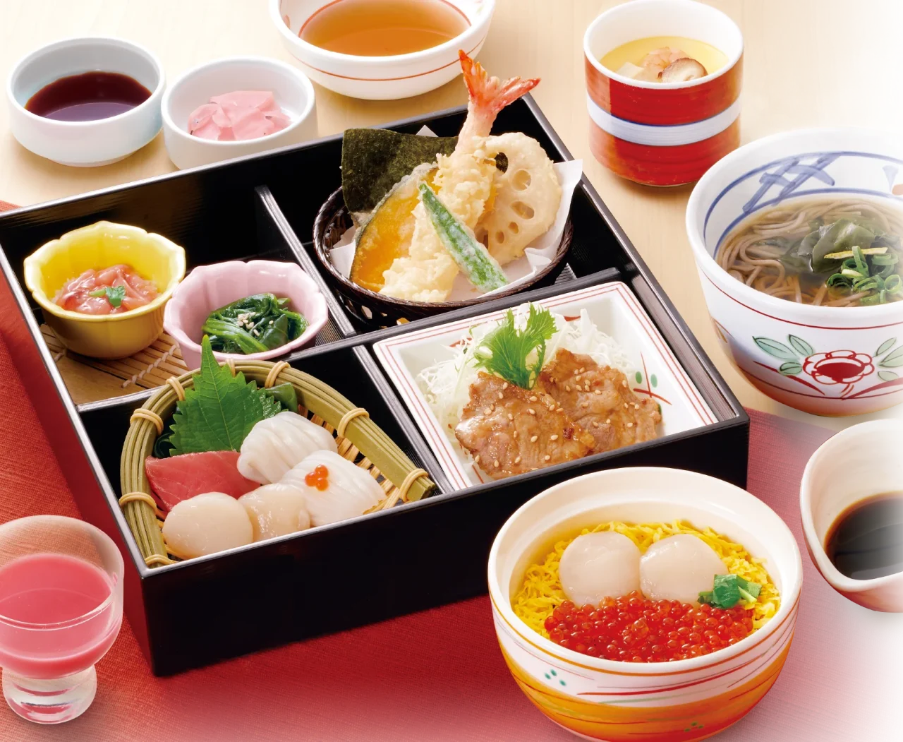 北海づくし御膳。黒い御膳に天ぷら、お造り、豚肩ロース焼、ミニ帆立いくら丼などが並ぶ