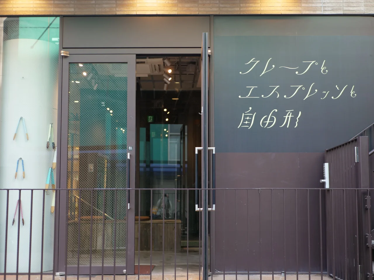 「クレープとエスプレッソと自由形」の看板がある店舗入口