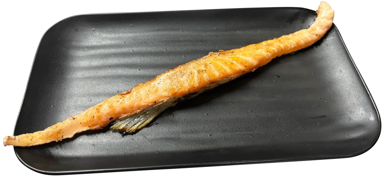 黒い角皿にのった焼き上がりの鮭ハラス焼き