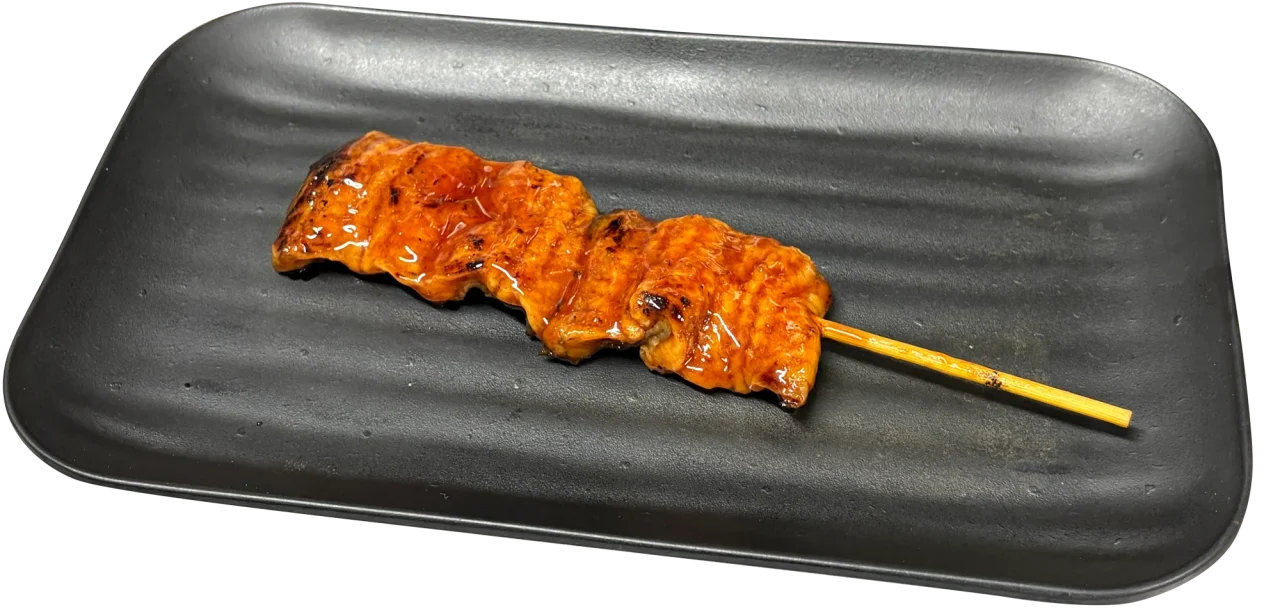 黒い長方形の皿にのったタレ焼きの「うなぎ串焼き」