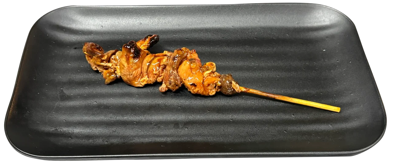 黒い長方形の皿にのったうなぎ肝串焼き