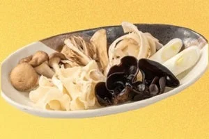 鴨しゃぶ茸セット。皿に茸やきくらげ、白ねぎを盛り合わせた様子