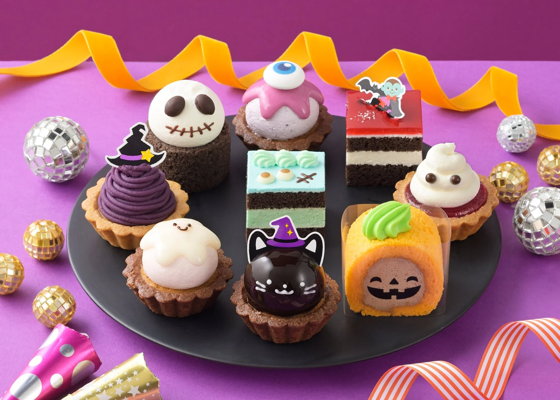 黒い皿に並んだ、おばけや黒猫などハロウィンデザインのプチケーキ