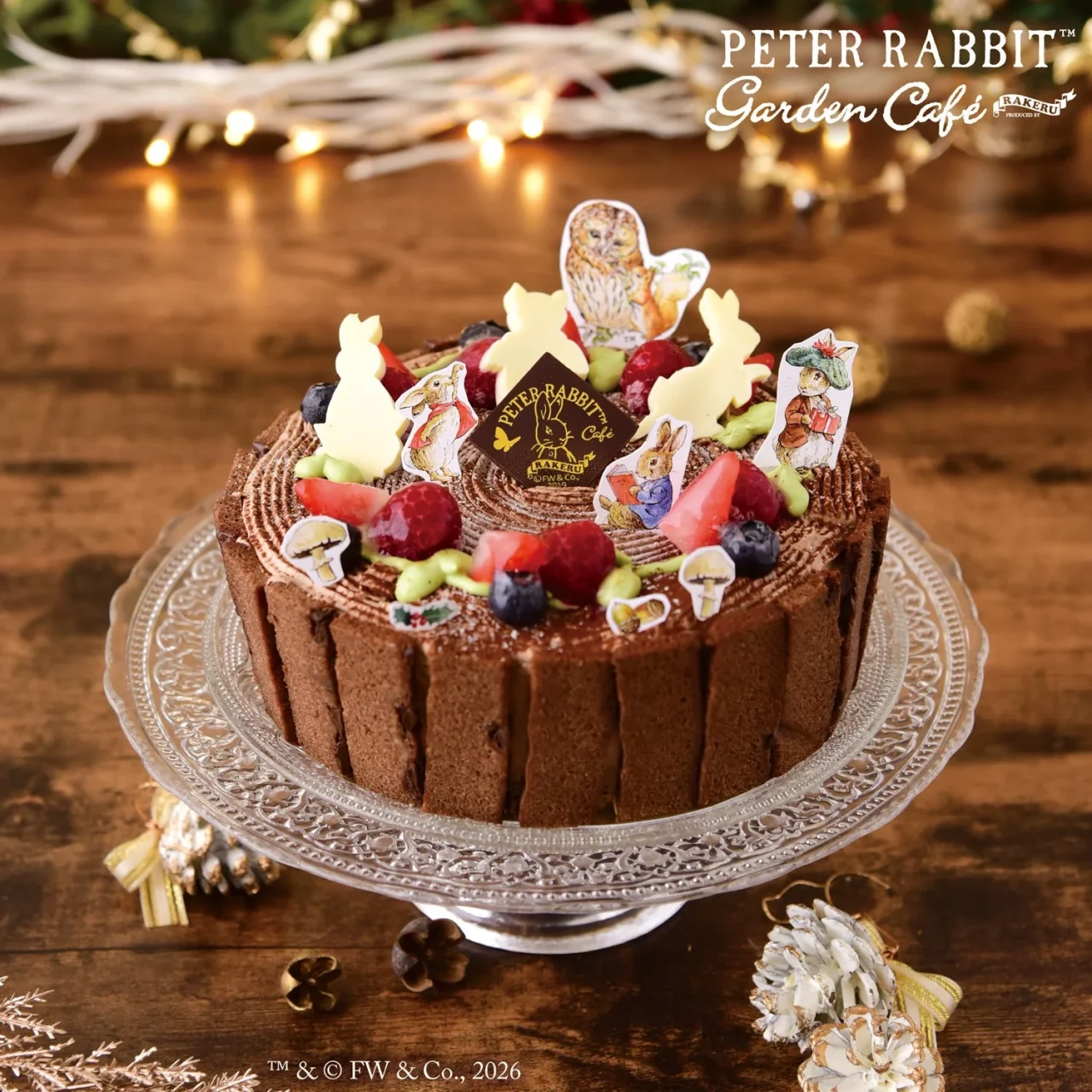 ピーターラビット™の森の切り株クリスマスケーキ。デコレーションパーツと果物を飾った