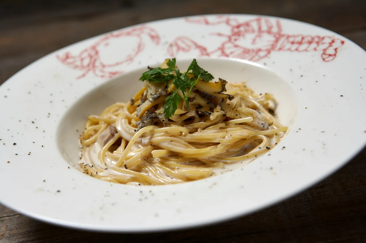アワビとポルチーニ茸の贅沢クリームパスタ。白い深皿に盛られたクリームパスタ