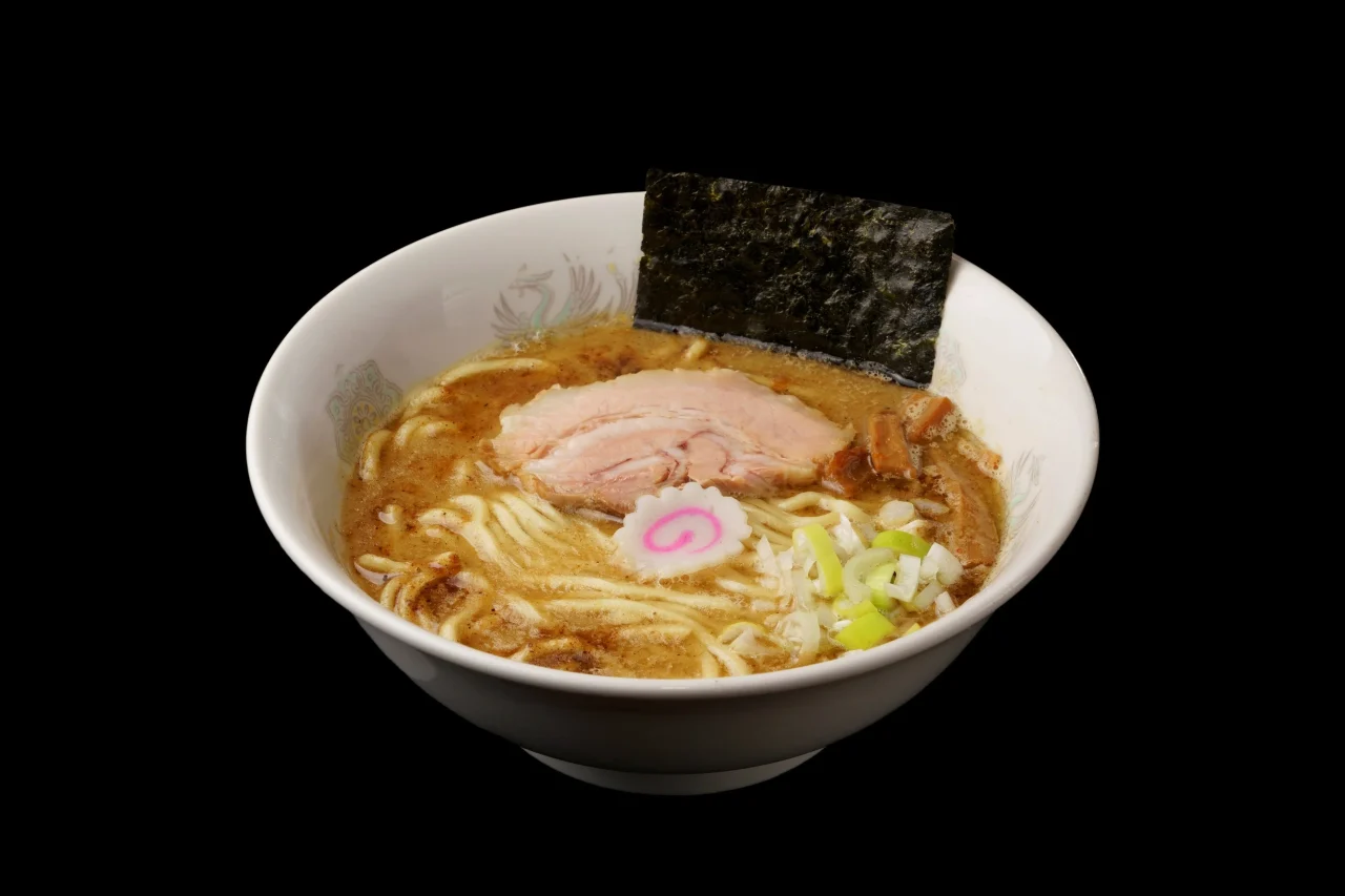 白い丼に入ったラーメン。海苔、チャーシュー、なると、ねぎがのる
