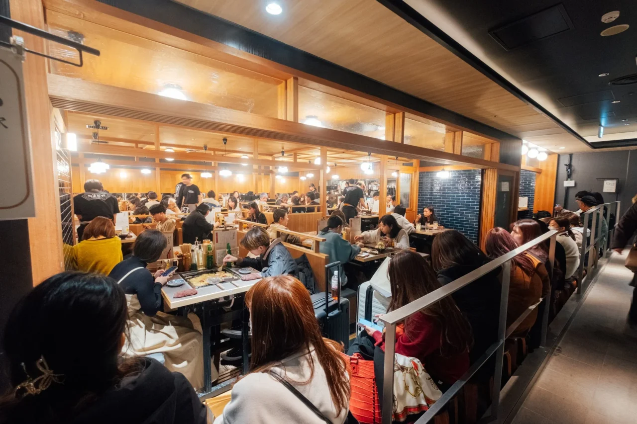 たまとや東京駅の店内。木調の個室風席で多くの客が食事をしている様子