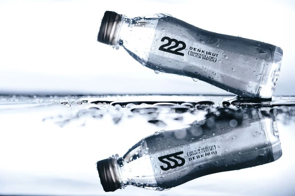 水面に横たわるデンキスイのシリカ水ペットボトルと反射