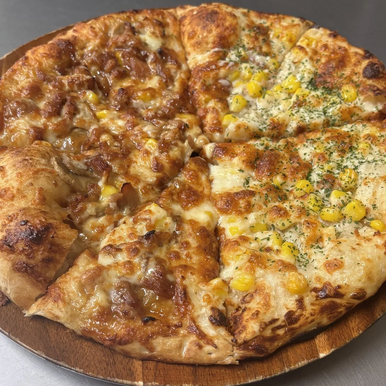 照焼チキンとたっぷりコーンのハーフ。木皿にコーンとチーズのピザ
