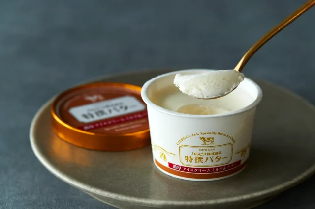 カルピス㈱特撰バター 濃厚アイスクリーム ミルク＆バターのカップとスプーンですくったアイス