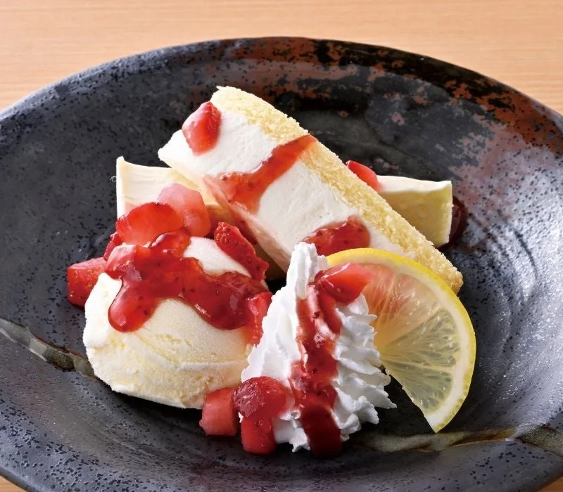 レアチーズケーキ ～ストロベリーソースがけ～。アイスと生クリーム、レモン添え