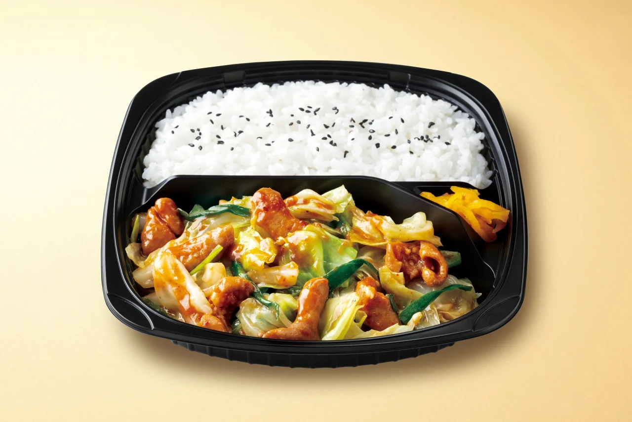 牛ホルモンのピリ辛味噌炒め弁当。白ごはんと炒め物が入った黒い容器