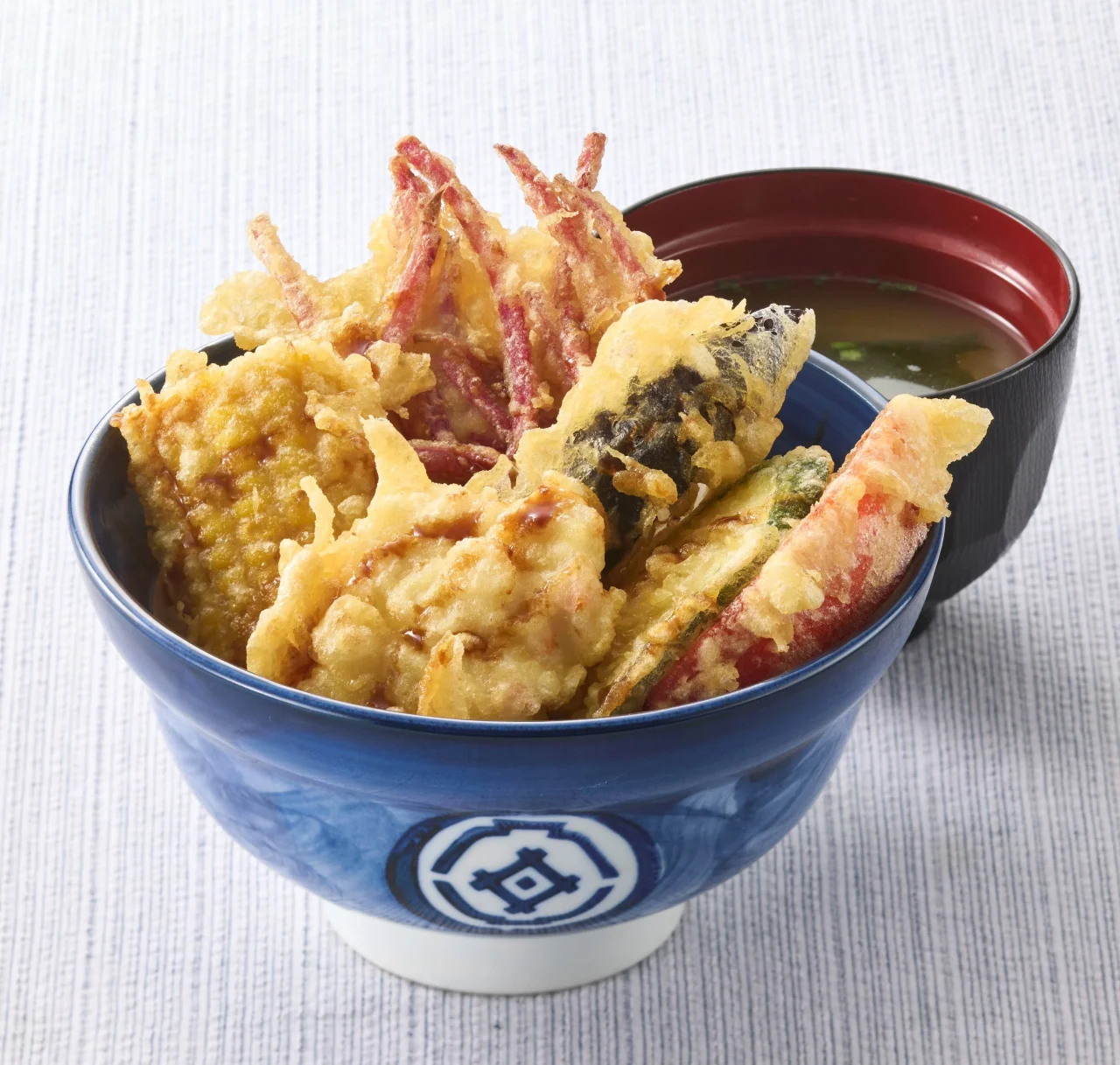 鮮やか ベジポテ天丼（みそ汁付）。青い丼に天ぷらを盛り、みそ汁が添えられている