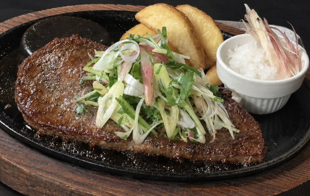 学生ハンバーグ 香味野菜おろし。薬味野菜をのせ、大根おろしとポテトを添えた鉄板