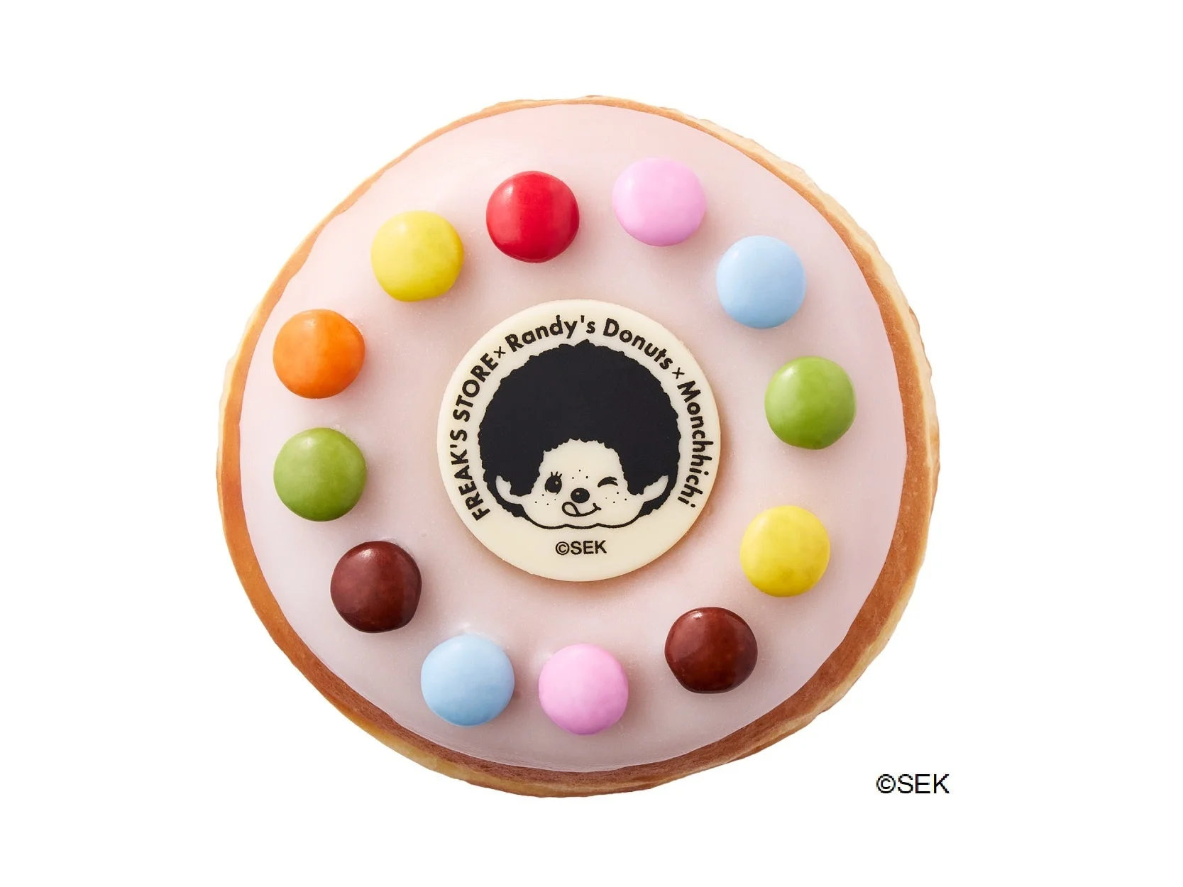 モンチッチ レイズド。ピンクの白いアイシングにカラフルなチョコ菓子とモンチッチのプレート