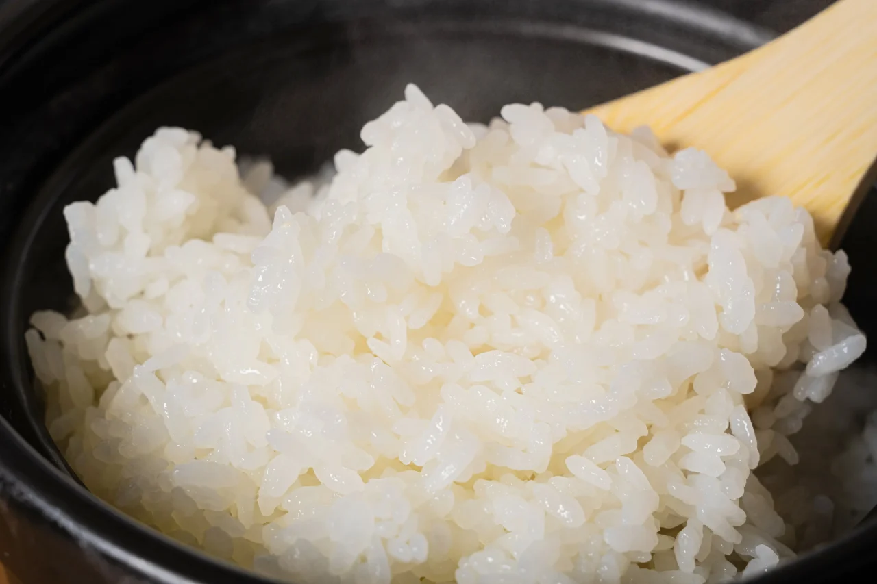 釜で炊いた熱々のご飯。木のしゃもじが添えられた白米のアップ
