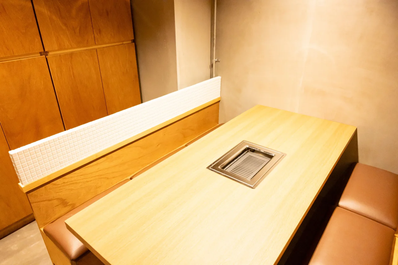 浜松町 たれ焼肉のんき 裏の店内、ロースター付き木製テーブル席