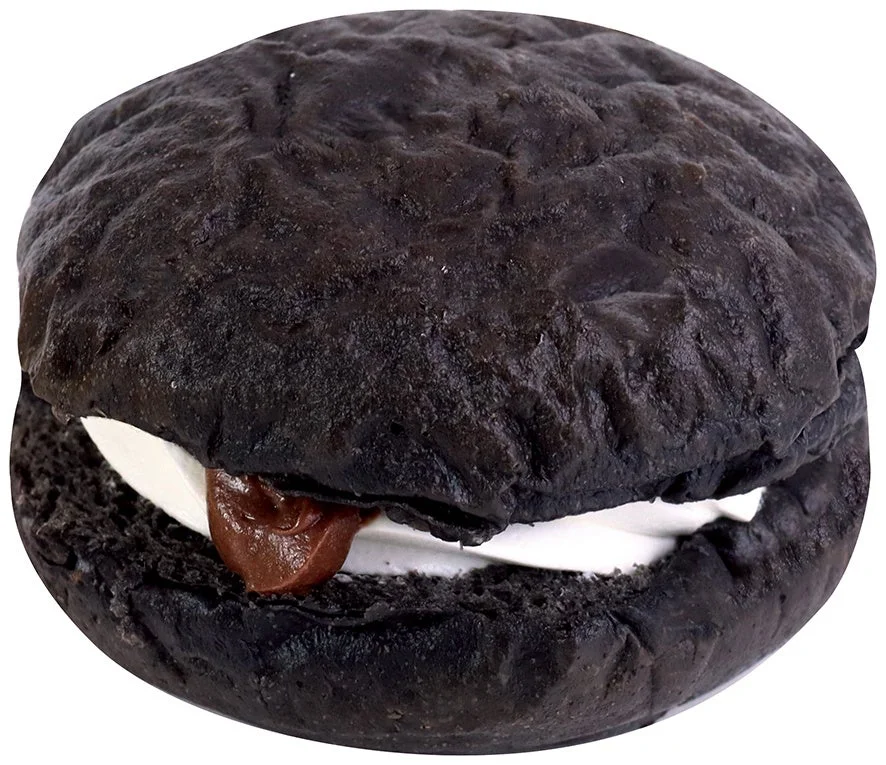 不二家の生ドーナツ（ブラック）。真っ黒な生地に白いクリームとチョコ