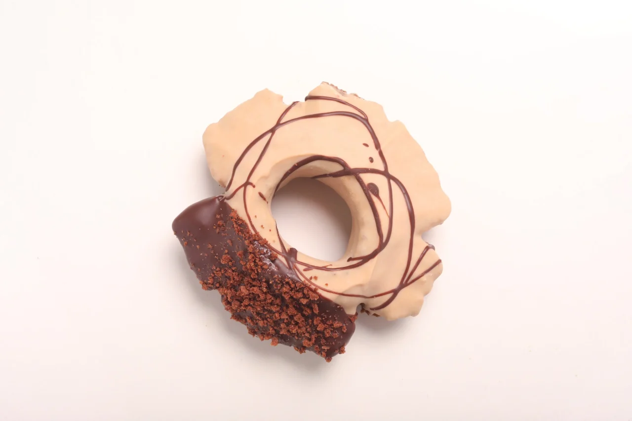 珈琲ファッション。茶色のチョコ線と一部にチョコとクランブルがかかったリング型ドーナツ