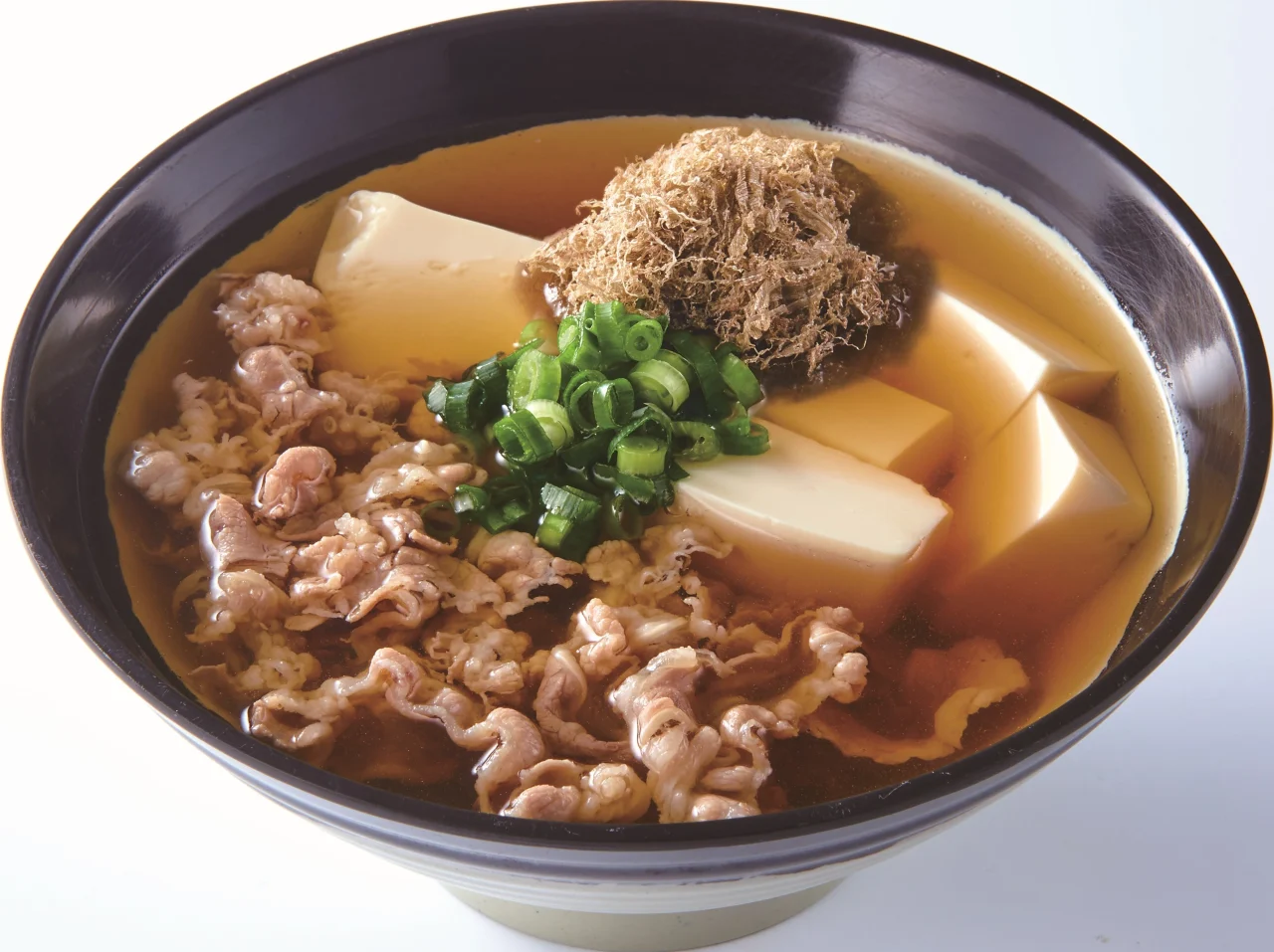 肉吸い 豆腐入り。黒い丼に薄切り肉、豆腐、ネギ、かすがのったお出汁