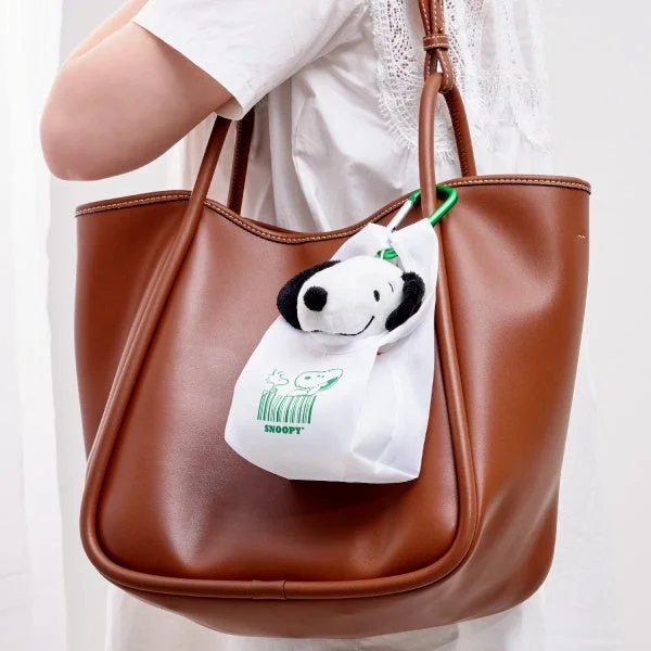 SNOOPY おかいものマスコットを茶色のバッグに付けた様子