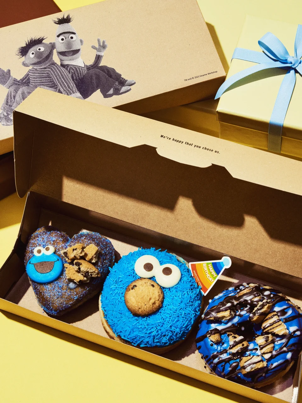 ハッピーバースデークッキー ドーナツ3個BOX。ハート型、クッキーモンスター顔、青いチョコがけの3種