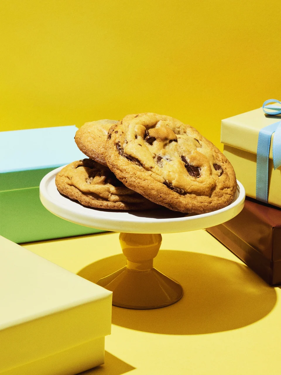 Cookie Monster'sクッキー。白いケーキスタンドに載った大きなチョコチップクッキー