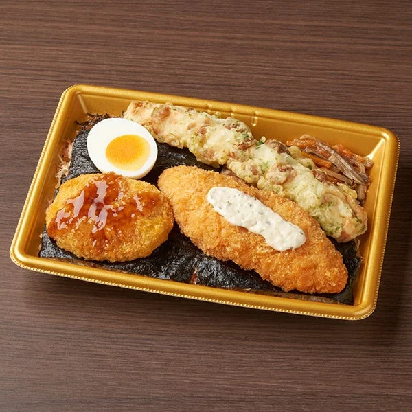 ファミマ・ザ・海苔弁当。海苔の上にコロッケ、白身魚フライ、ゆで玉子などを盛り付け