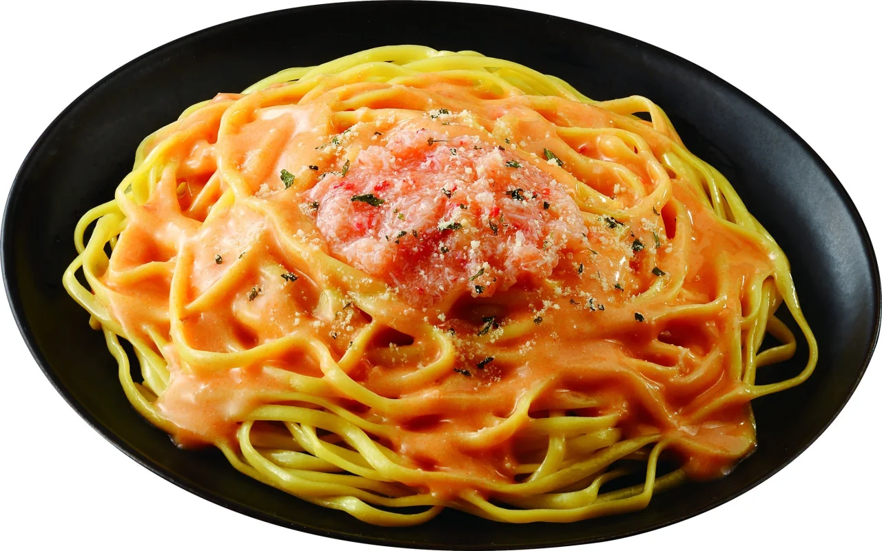 生パスタ 濃厚カニクリーム。黒皿に盛った平打ち麺とカニフレーク